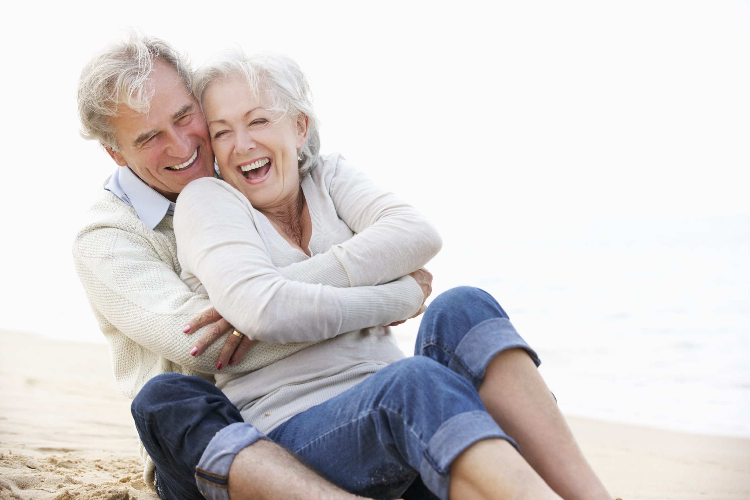 elderly_couple_smiling_on_beach